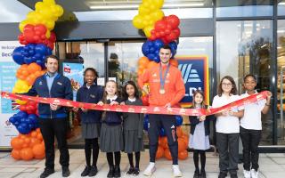 Team GB Olympian Toby Harries and store manager Giuseppe Daniello cut the ribbon at Aldi with children from North Beckton Primary School