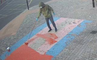 The police wish to speak with the masked and hooded figure after Pride, progress, and transgender flags outside Forest Gate station were vandalised